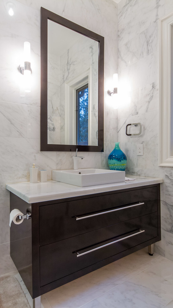 Small contemporary powder room in Toronto with flat-panel cabinets, black cabinets, engineered quartz benchtops, white tile, ceramic floors and stone tile.