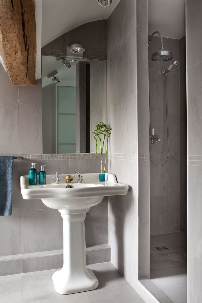 Photo of a mid-sized contemporary master bathroom in Paris with a curbless shower, gray tile, cement tile, grey walls, a pedestal sink, grey floor, an open shower and ceramic floors.