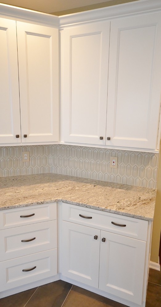 This is an example of a mid-sized transitional l-shaped eat-in kitchen in Philadelphia with an undermount sink, recessed-panel cabinets, white cabinets, granite benchtops, beige splashback, mosaic tile splashback, stainless steel appliances, ceramic floors and no island.