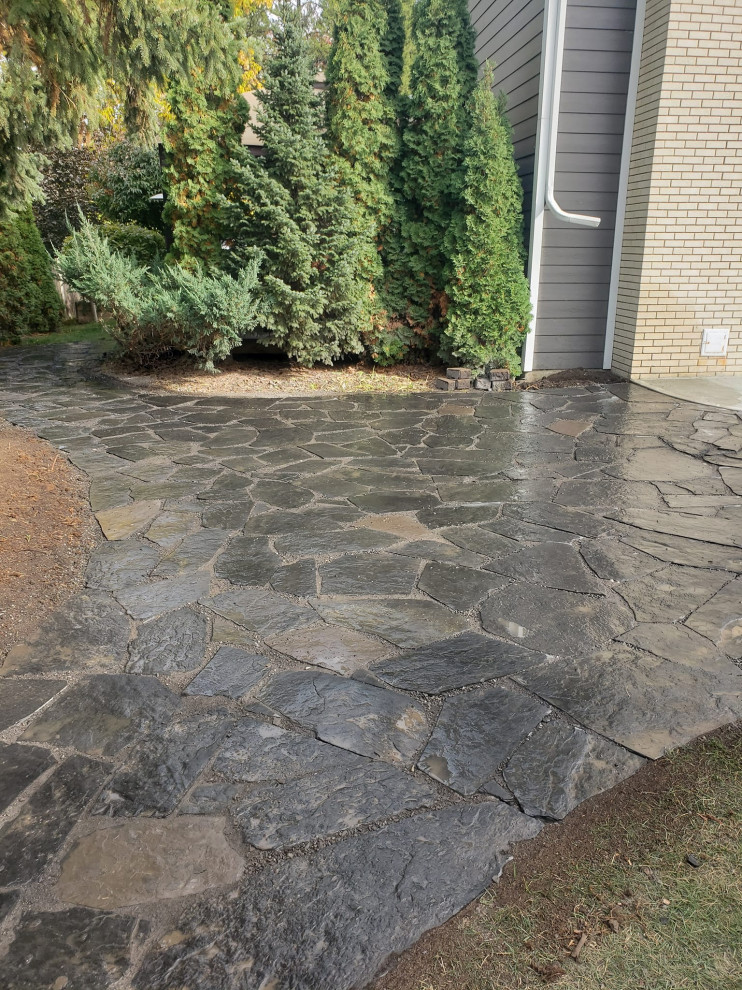 Design ideas for a mid-sized rustic partial sun backyard stone landscaping in Edmonton for summer.