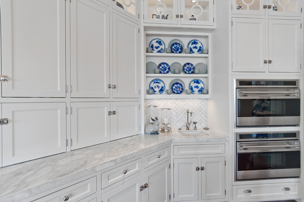 Riverton - Ewell - Elegant medium tone wood floor and brown floor kitchen photo in Salt Lake City with an undermount sink, recessed-panel cabinets, white cabinets, marble countertops, white backsplash, marble backsplash and white countertops