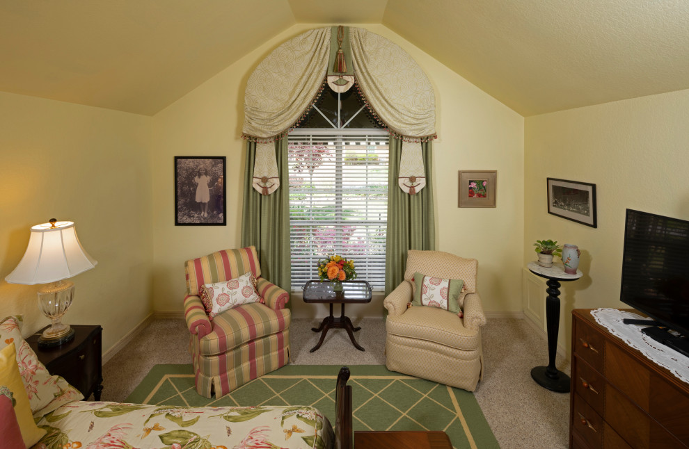 На фото: хозяйская спальня в классическом стиле с желтыми стенами и ковровым покрытием с