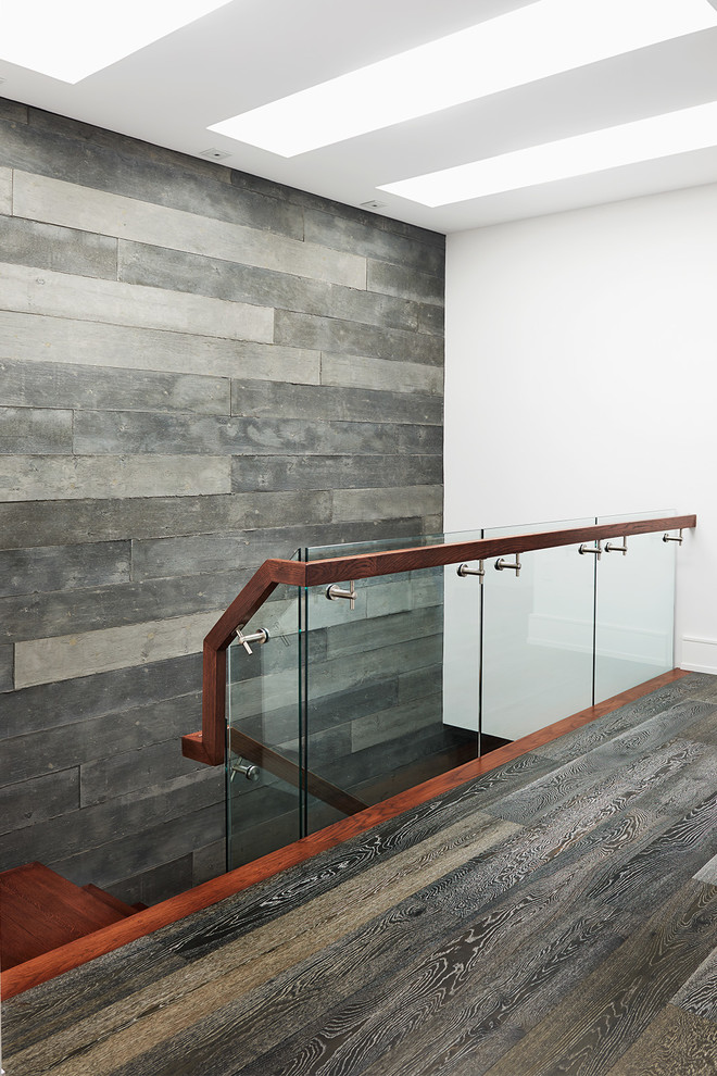 Photo of a mid-sized modern wood straight staircase in Toronto with open risers and glass railing.