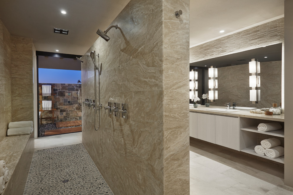 Photo of a large master bathroom in Other with flat-panel cabinets, white cabinets, gray tile, beige tile, limestone, beige walls, porcelain floors, a drop-in sink, limestone benchtops, grey floor, an open shower and a double shower.