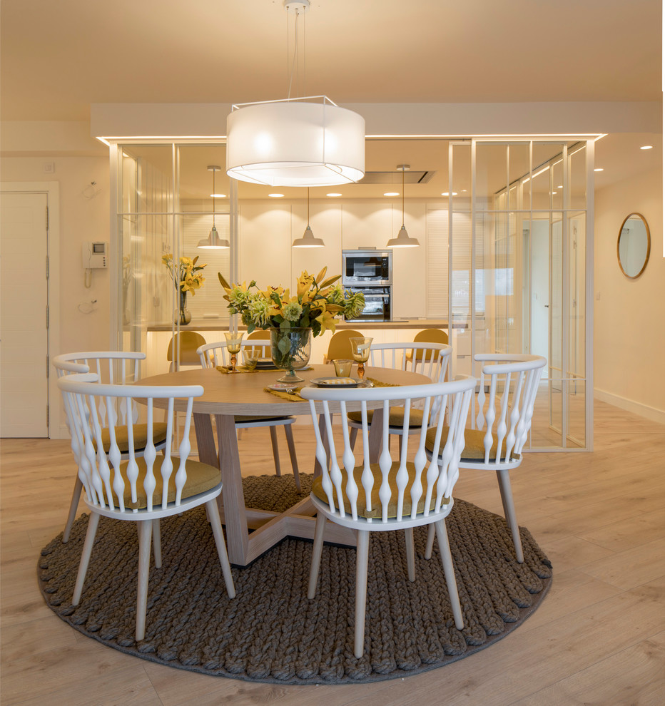 Modelo de comedor tradicional renovado grande abierto sin chimenea con paredes blancas, suelo laminado y suelo beige