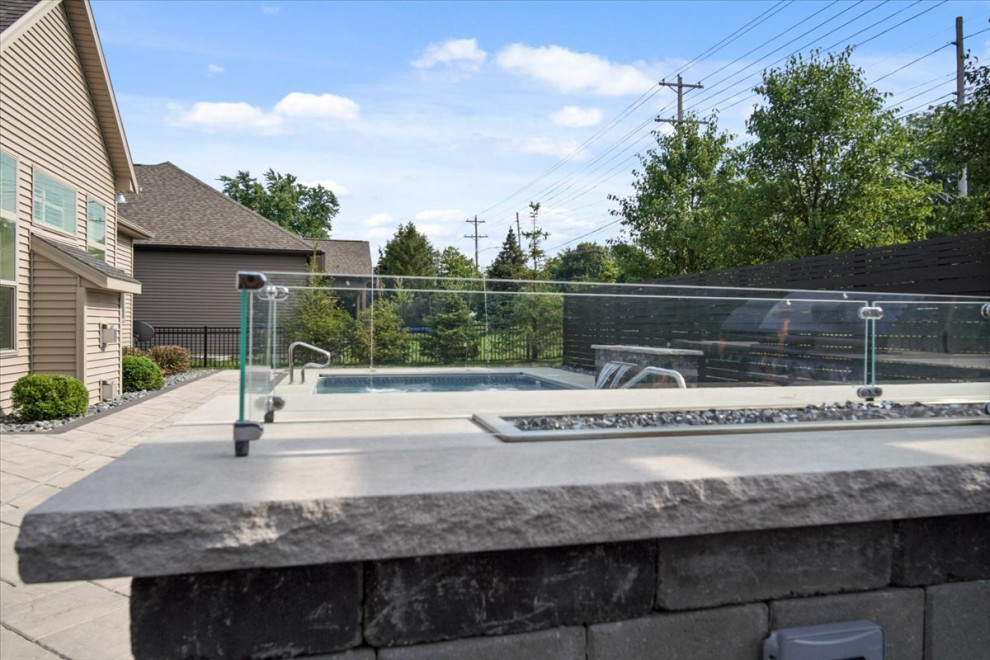 Ispirazione per una piscina monocorsia minimalista rettangolare di medie dimensioni e dietro casa con fontane e pavimentazioni in cemento