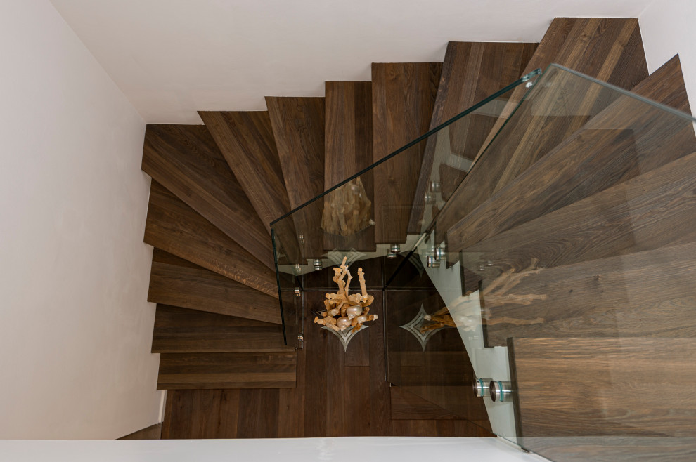 Стильный дизайн: изогнутая лестница в классическом стиле с деревянными ступенями - последний тренд