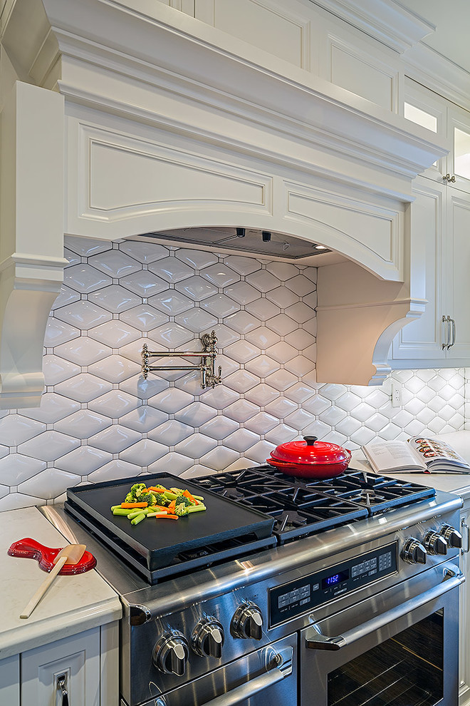 Inspiration for a mid-sized transitional l-shaped enclosed kitchen remodel in Toronto with white cabinets, quartz countertops and an island