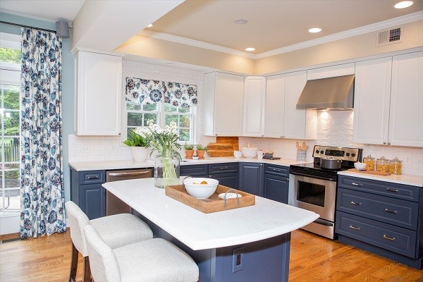 Transitional l-shaped kitchen in DC Metro with an undermount sink, flat-panel cabinets, white cabinets, quartz benchtops, white splashback, subway tile splashback, stainless steel appliances, light hardwood floors and with island.