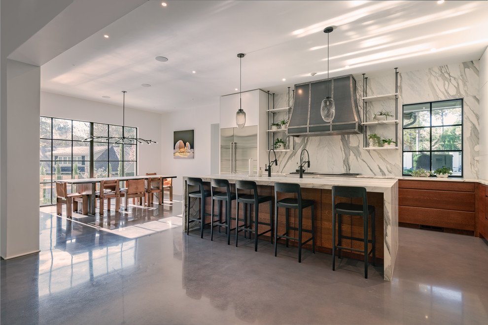 Example of a concrete floor and gray floor kitchen pantry design with an undermount sink, flat-panel cabinets, white cabinets, marble countertops, gray backsplash, marble backsplash, stainless steel appliances, an island and gray countertops