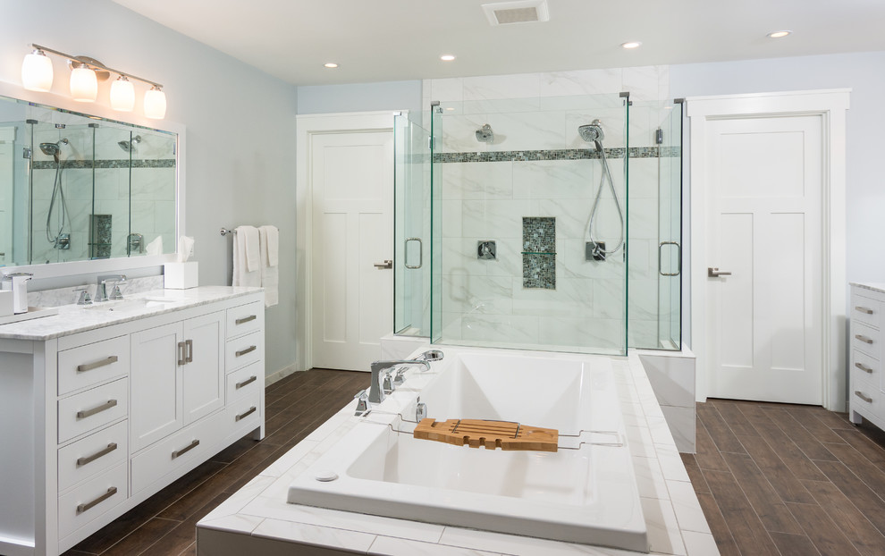 Photo of a large transitional master bathroom in Detroit with shaker cabinets, white cabinets, marble benchtops, brown tile, porcelain tile, a drop-in tub, an open shower, an undermount sink, a two-piece toilet, blue walls and porcelain floors.