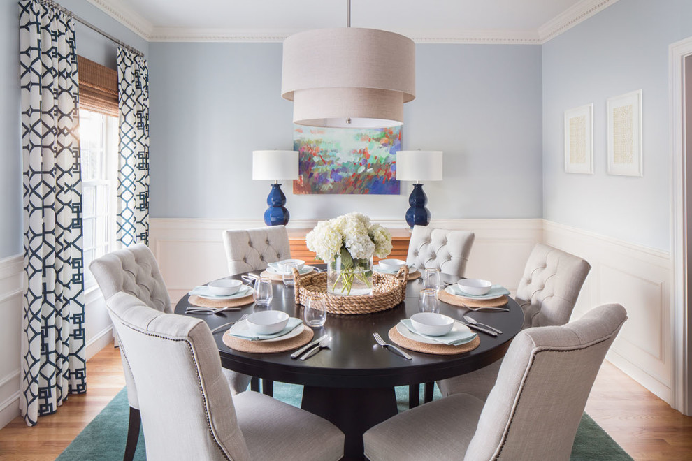 Photo of a transitional dining room in Boston with blue walls and light hardwood floors.