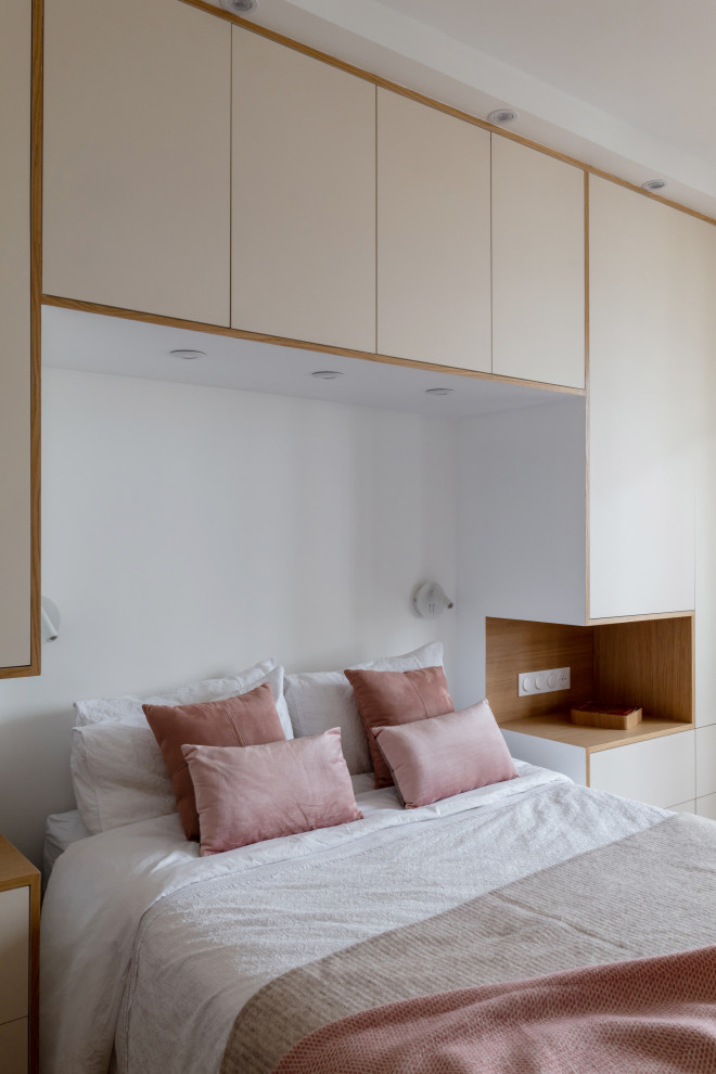 Стильный дизайн: хозяйская спальня среднего размера, в белых тонах с отделкой деревом в скандинавском стиле с белыми стенами, светлым паркетным полом и панелями на стенах - последний тренд
