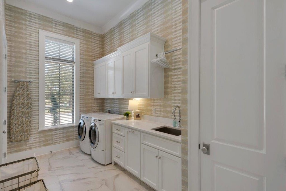 Inspiration for a large country single-wall dedicated laundry room in Miami with an undermount sink, shaker cabinets, white cabinets, beige walls, marble floors, a side-by-side washer and dryer, beige floor and marble benchtops.