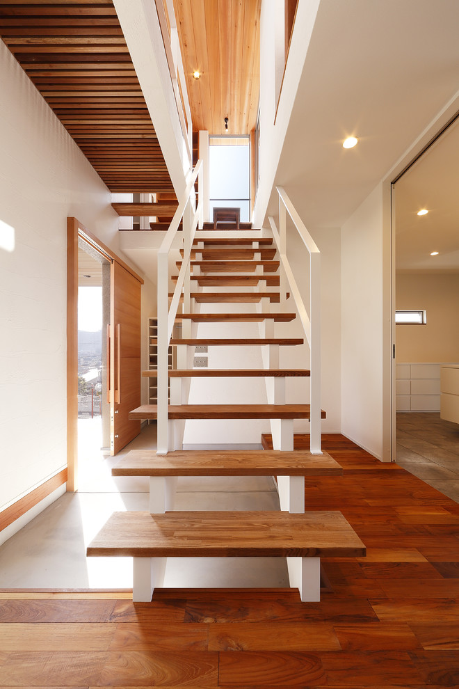 Photo of a contemporary wood straight staircase in Other with open risers and metal railing.