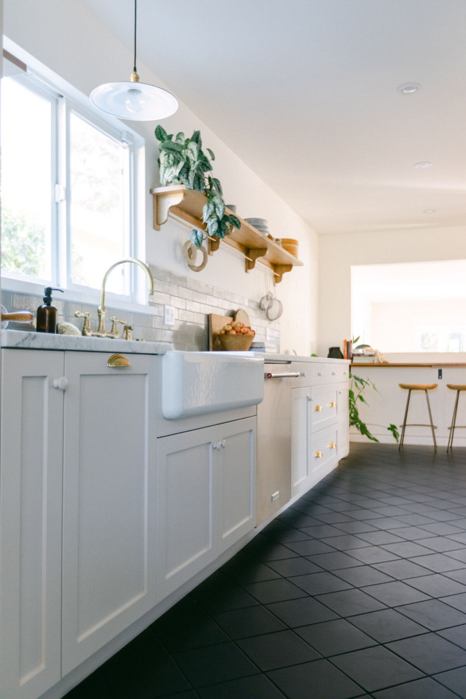 Beach style kitchen in Los Angeles with brick splashback and ceramic floors.