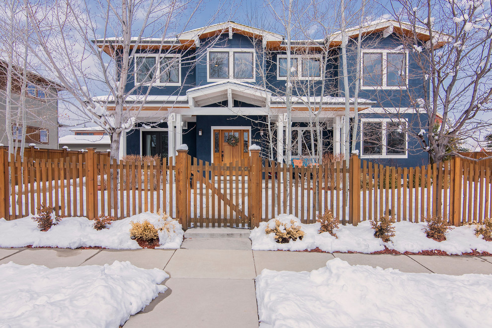 Large traditional two-storey blue house exterior in Denver with wood siding and a gable roof.