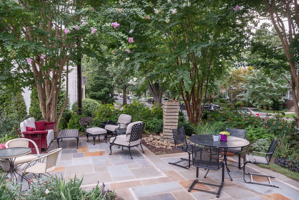 This is an example of a mid-sized contemporary front yard patio in DC Metro with a water feature and natural stone pavers.