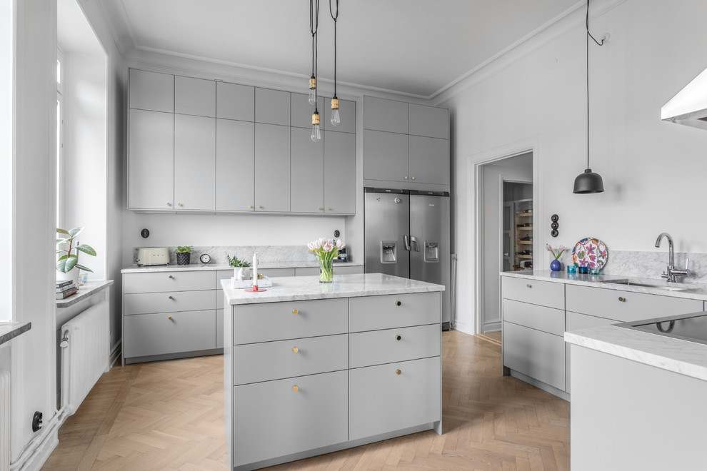 Design ideas for a large scandinavian u-shaped separate kitchen in Stockholm with a single-bowl sink, flat-panel cabinets, grey cabinets, marble benchtops, grey splashback, marble splashback, stainless steel appliances, light hardwood floors, with island, beige floor and grey benchtop.
