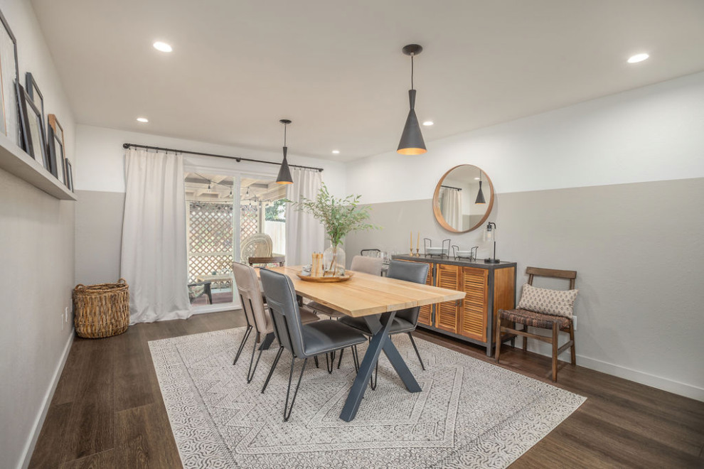 Immagine di una sala da pranzo aperta verso la cucina american style di medie dimensioni con pareti multicolore, pavimento in vinile e pavimento marrone