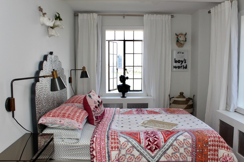 Small eclectic master bedroom in New York with white walls, dark hardwood floors and no fireplace.