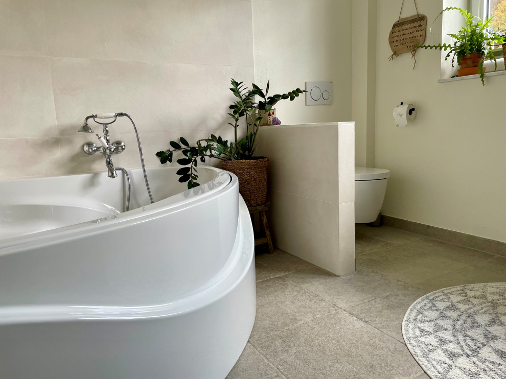 Inredning av ett lantligt mycket stort en-suite badrum, med öppna hyllor, bruna skåp, ett hörnbadkar, en vägghängd toalettstol, grå väggar, klinkergolv i keramik, ett fristående handfat, träbänkskiva och grått golv