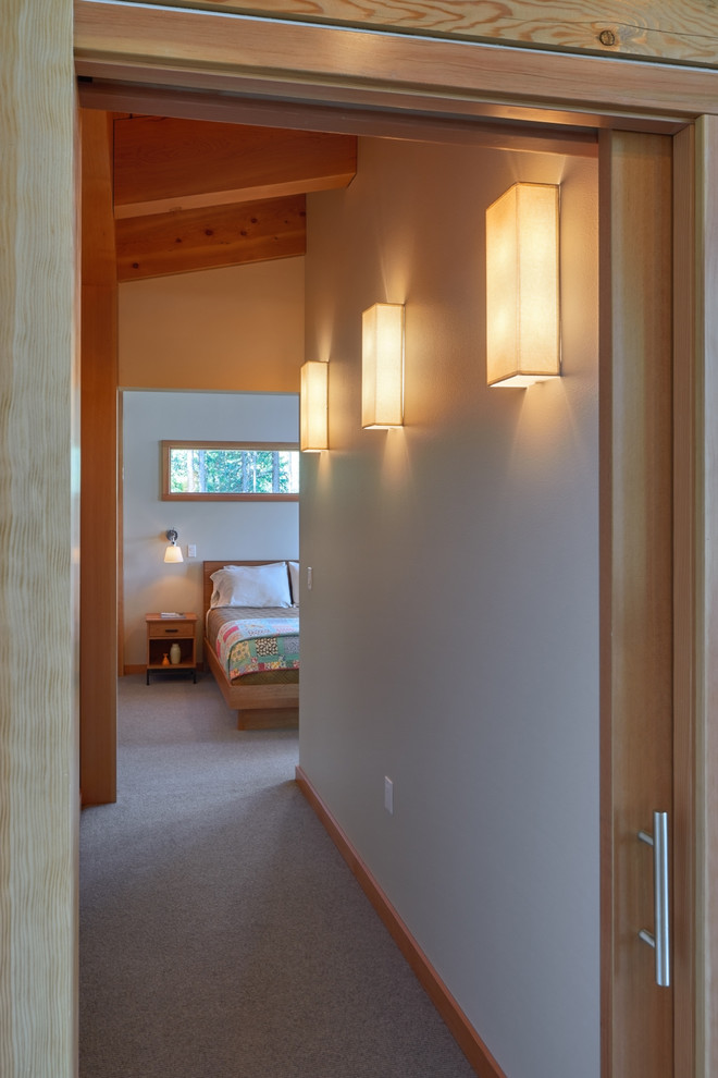 This is an example of a small contemporary hallway in Seattle with beige walls and carpet.