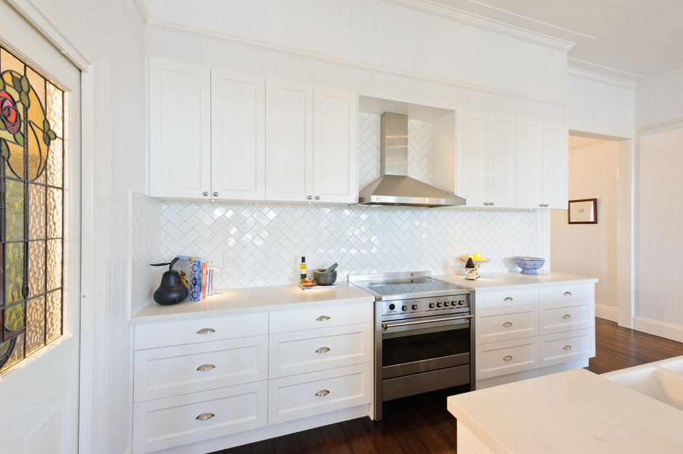 Inspiration for a large traditional single-wall open plan kitchen in Brisbane with shaker cabinets, white cabinets, white splashback, porcelain splashback, dark hardwood floors and with island.