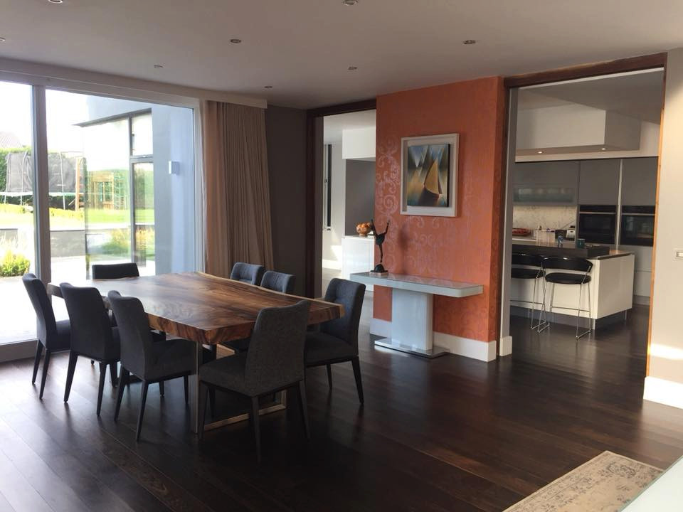 Large beach style kitchen/dining combo in Cork with grey walls, dark hardwood floors, brown floor and wallpaper.