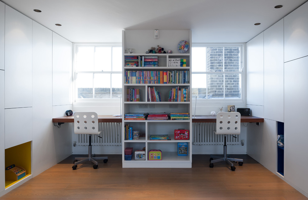 Design ideas for a contemporary gender-neutral kids' study room in London with white walls and light hardwood floors.