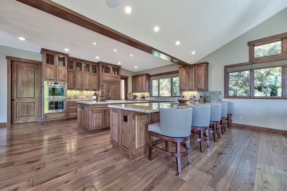 Example of a huge transitional u-shaped medium tone wood floor and multicolored floor open concept kitchen design with a double-bowl sink, raised-panel cabinets, medium tone wood cabinets, granite countertops, multicolored backsplash, stone slab backsplash, paneled appliances, an island and multicolored countertops