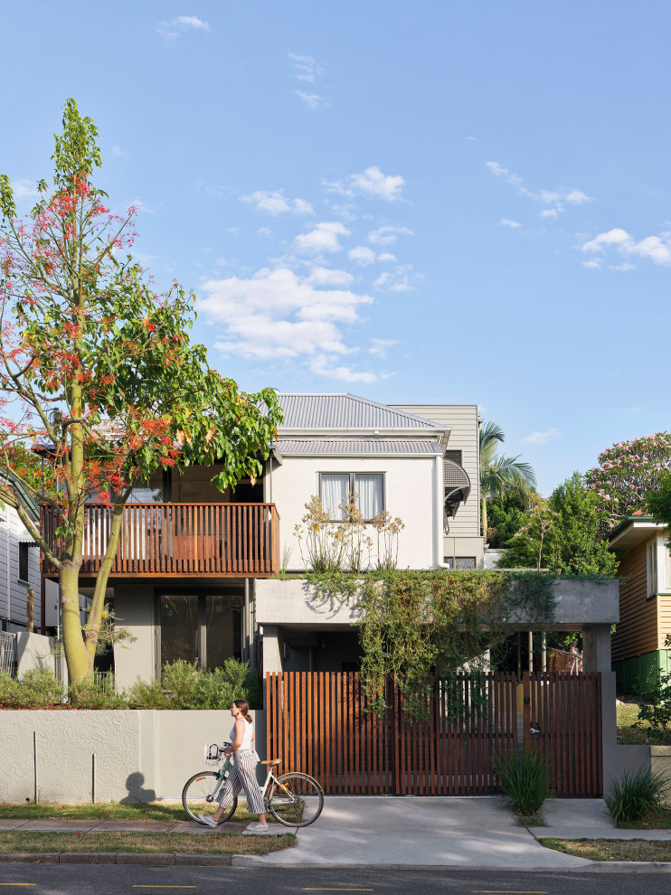 Immagine della villa beige contemporanea a due piani con rivestimento in stucco, copertura in metallo o lamiera, tetto grigio e pannelli e listelle di legno