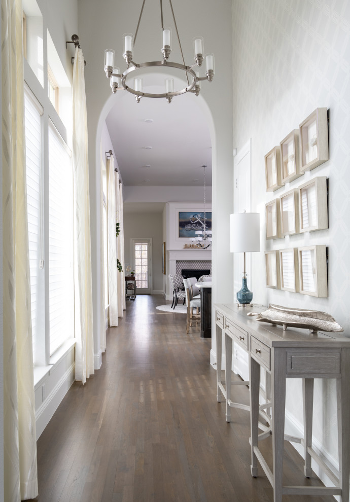 ダラスにある高級な中くらいなトランジショナルスタイルのおしゃれな玄関ロビー (ベージュの壁、淡色無垢フローリング、濃色木目調のドア、茶色い床、壁紙) の写真