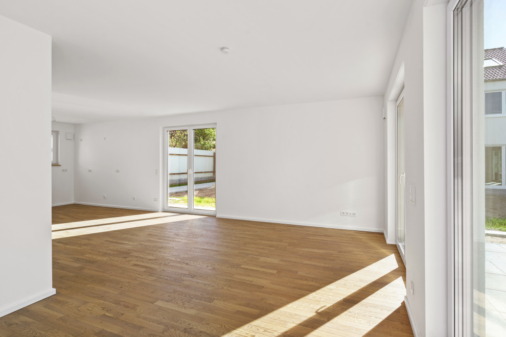Ispirazione per un soggiorno minimal di medie dimensioni e aperto con pareti bianche, pavimento in laminato e pavimento marrone