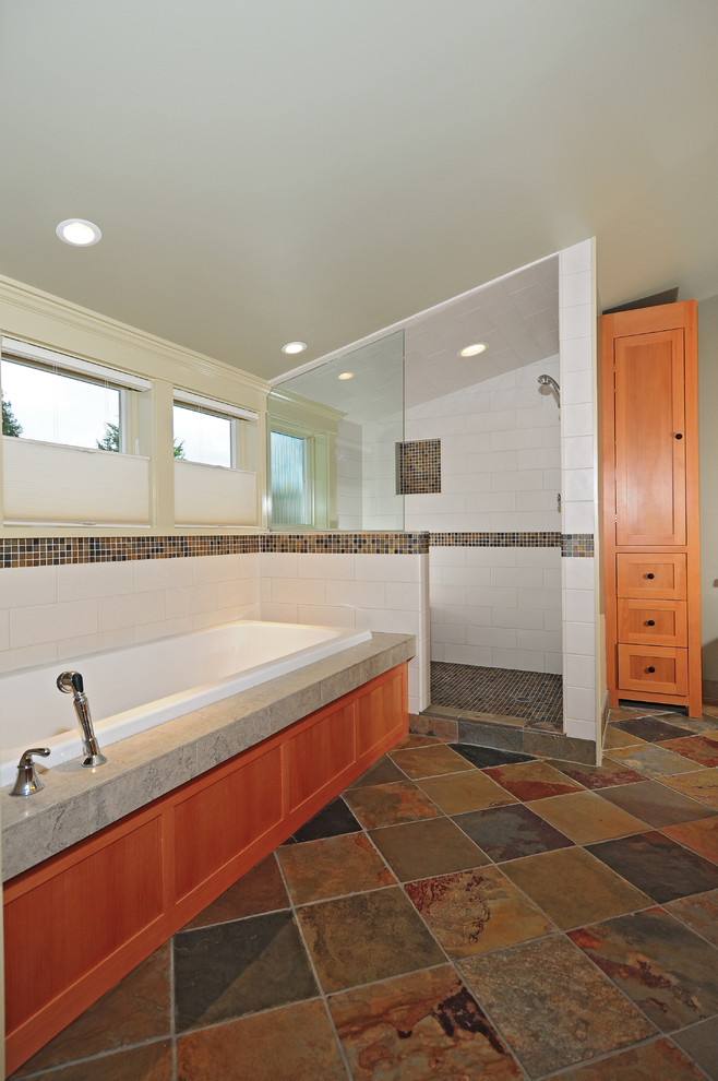 Photo of an arts and crafts master bathroom in Seattle with a drop-in sink, shaker cabinets, medium wood cabinets, a drop-in tub, an alcove shower, a two-piece toilet, multi-coloured tile, grey walls and slate floors.
