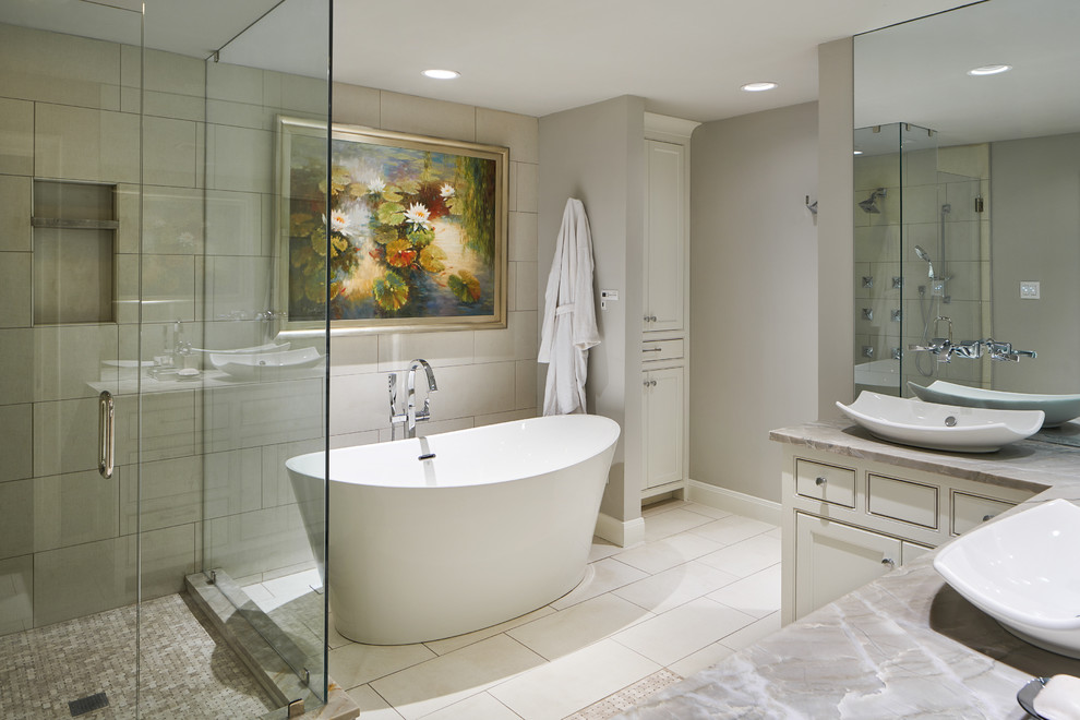 Design ideas for a large transitional master bathroom in Other with recessed-panel cabinets, white cabinets, a freestanding tub, a corner shower, a one-piece toilet, beige tile, ceramic tile, grey walls, ceramic floors, a vessel sink, onyx benchtops, beige floor and a hinged shower door.