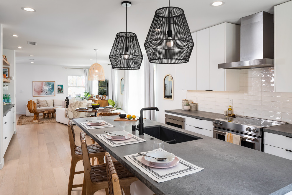 Inspiration for a small contemporary single-wall eat-in kitchen in San Diego with an undermount sink, flat-panel cabinets, white cabinets, quartz benchtops, white splashback, glass tile splashback, stainless steel appliances, medium hardwood floors, with island and grey benchtop.