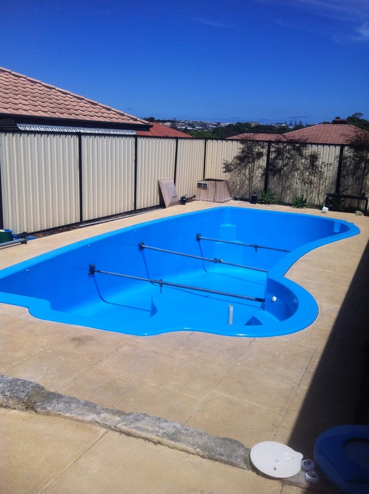 This is an example of a mid-sized modern backyard custom-shaped pool in Perth with concrete slab.