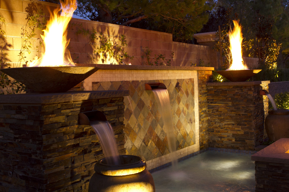 Design ideas for a mid-sized mediterranean backyard partial sun garden in Las Vegas with a water feature and concrete pavers.