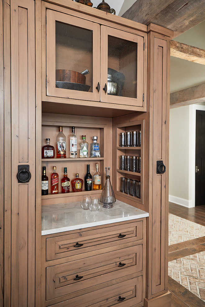 This is an example of a small industrial single-wall home bar in Grand Rapids with raised-panel cabinets, light wood cabinets, granite benchtops, timber splashback, medium hardwood floors and white benchtop.