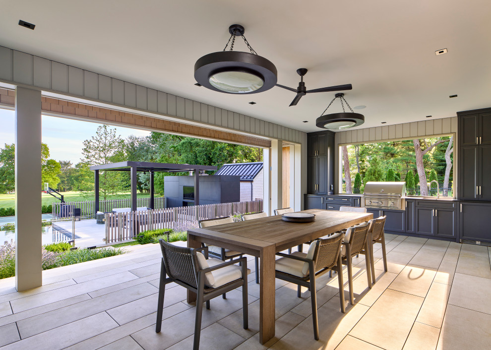 Foto de terraza planta baja minimalista de tamaño medio en patio trasero y anexo de casas con cocina exterior y barandilla de metal