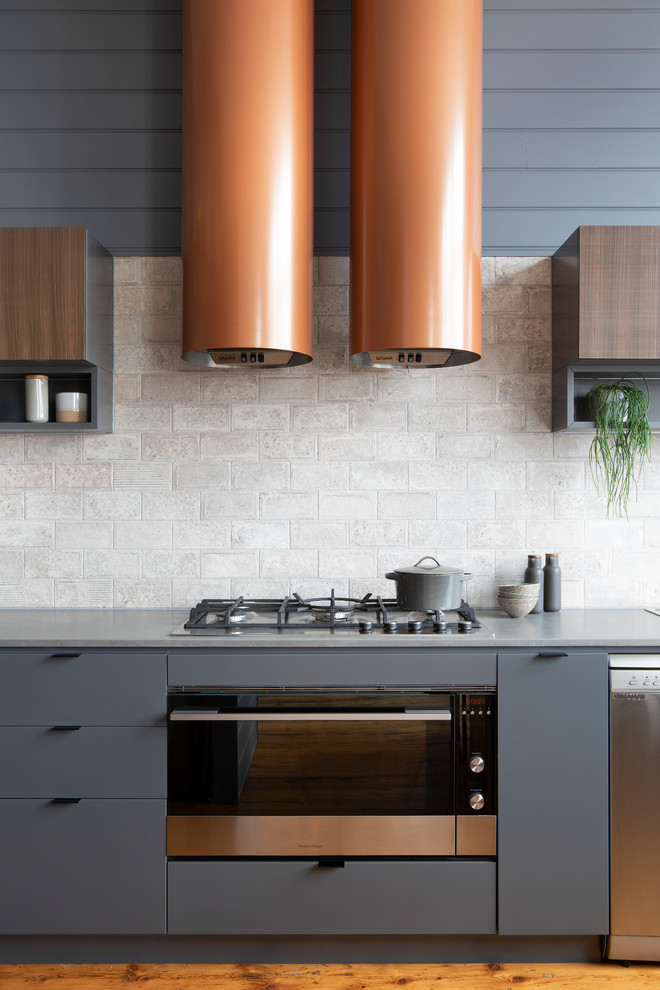 This is an example of a mid-sized contemporary u-shaped eat-in kitchen in Melbourne with a double-bowl sink, flat-panel cabinets, grey cabinets, quartz benchtops, grey splashback, ceramic splashback, stainless steel appliances, medium hardwood floors, with island, brown floor and grey benchtop.