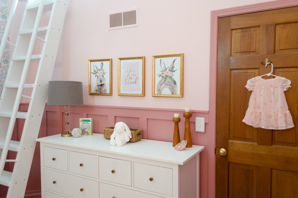 Aménagement d'une chambre de bébé fille classique avec un mur rose, moquette, un plafond voûté et boiseries.