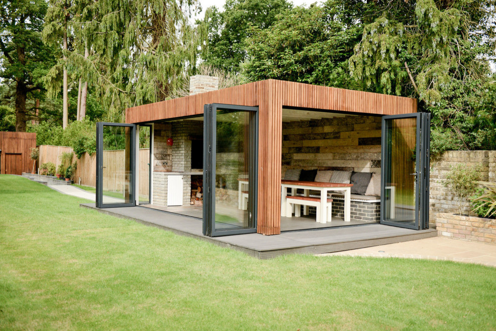 Idee per una veranda etnica di medie dimensioni con cornice del camino in mattoni e pavimento grigio