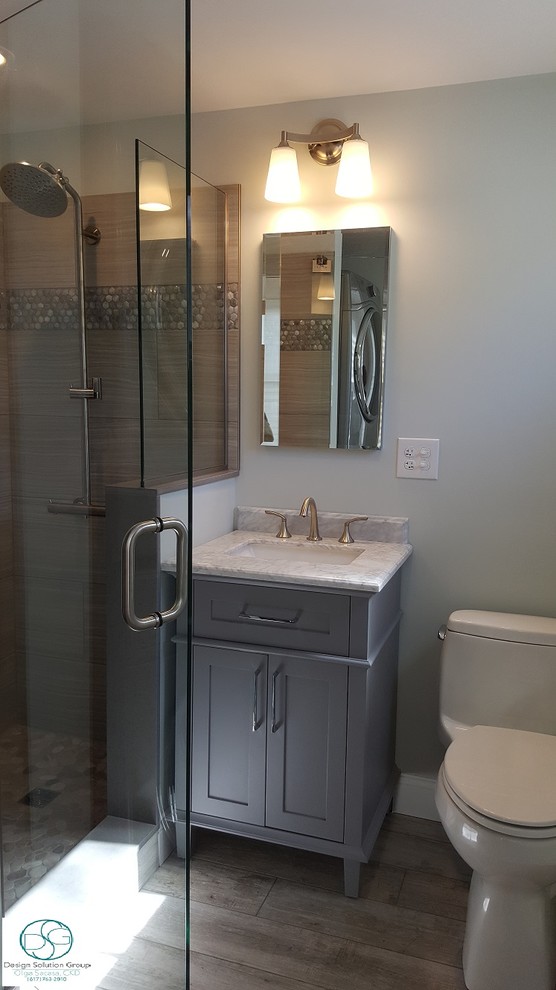 Photo of a small contemporary 3/4 bathroom in Boston with shaker cabinets, grey cabinets, an alcove shower, a one-piece toilet, gray tile, porcelain tile, grey walls, pebble tile floors, an undermount sink, marble benchtops, grey floor and a hinged shower door.
