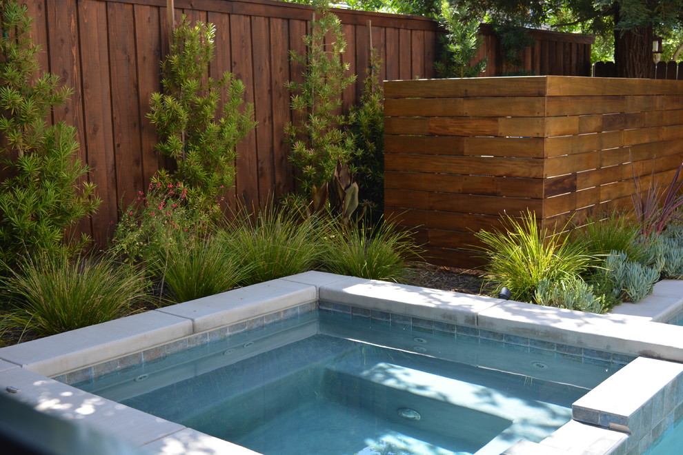 Small contemporary backyard custom-shaped pool in Sacramento with a hot tub and decking.