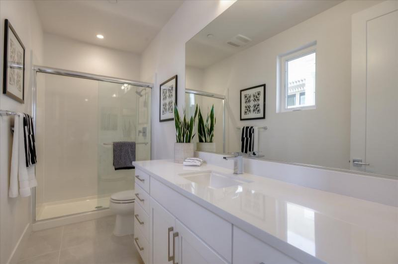 Immagine di una stanza da bagno con ante in stile shaker e ante bianche