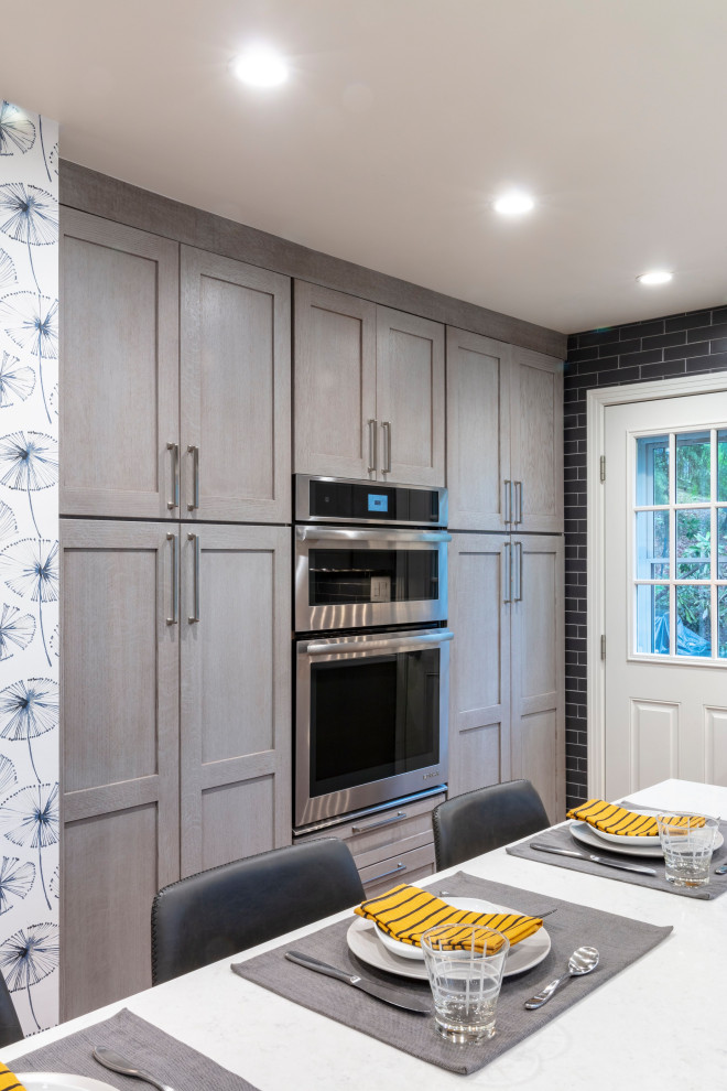 Inspiration for a contemporary u-shaped medium tone wood floor and brown floor eat-in kitchen remodel with an undermount sink, shaker cabinets, gray cabinets, quartz countertops, gray backsplash, ceramic backsplash, stainless steel appliances, an island and gray countertops