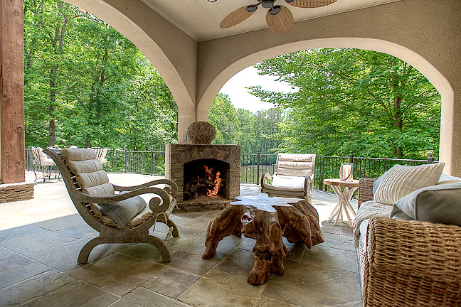 This is an example of an expansive mediterranean backyard deck in Atlanta with a roof extension.