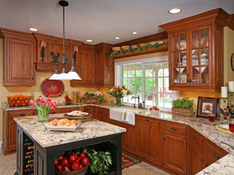 Mid-sized mountain style u-shaped enclosed kitchen photo in Miami with a farmhouse sink, raised-panel cabinets, medium tone wood cabinets, granite countertops, yellow backsplash and an island
